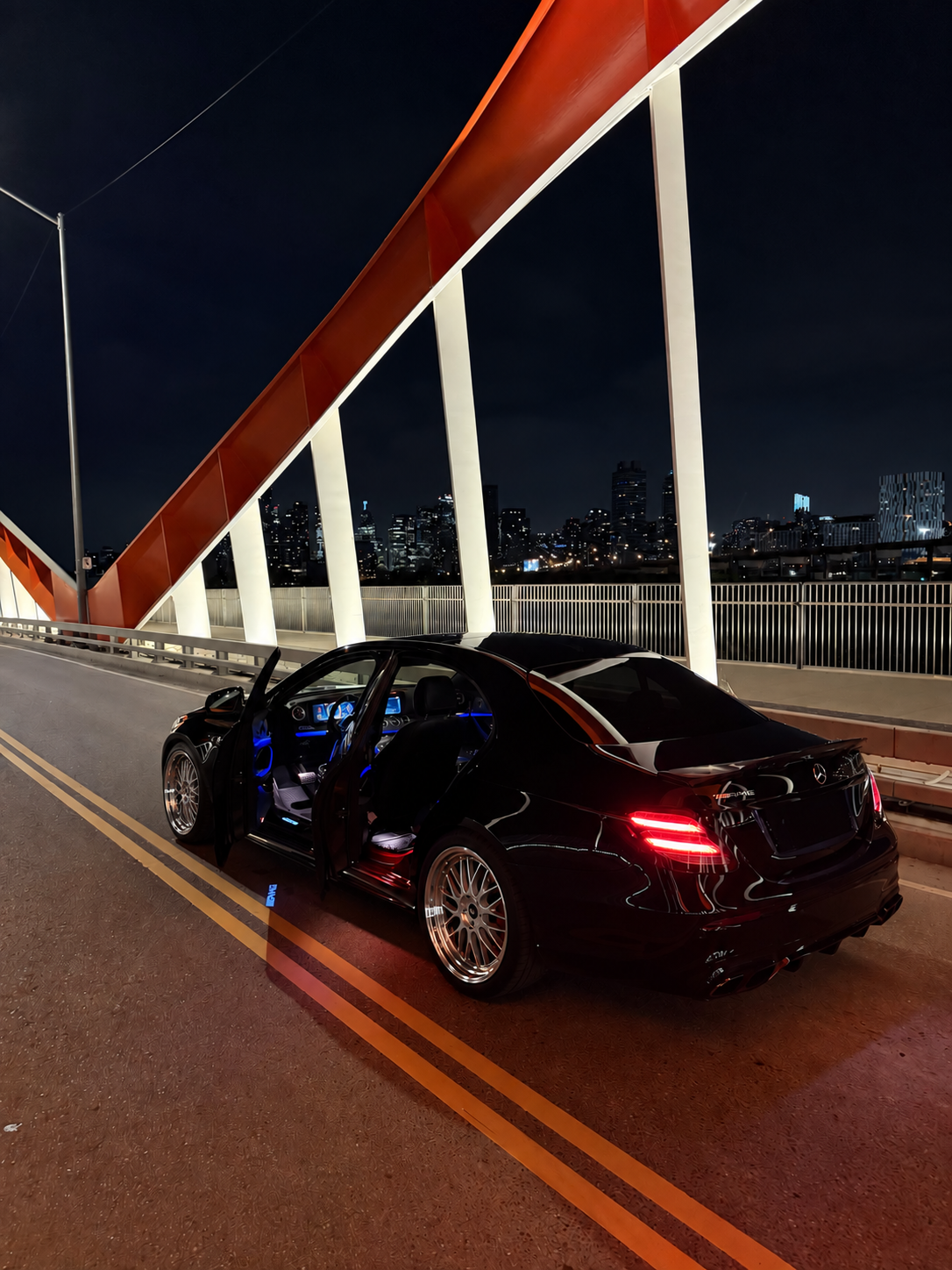 Streetcruises Mercedes-AMG on a Toronto bridge with its doors open